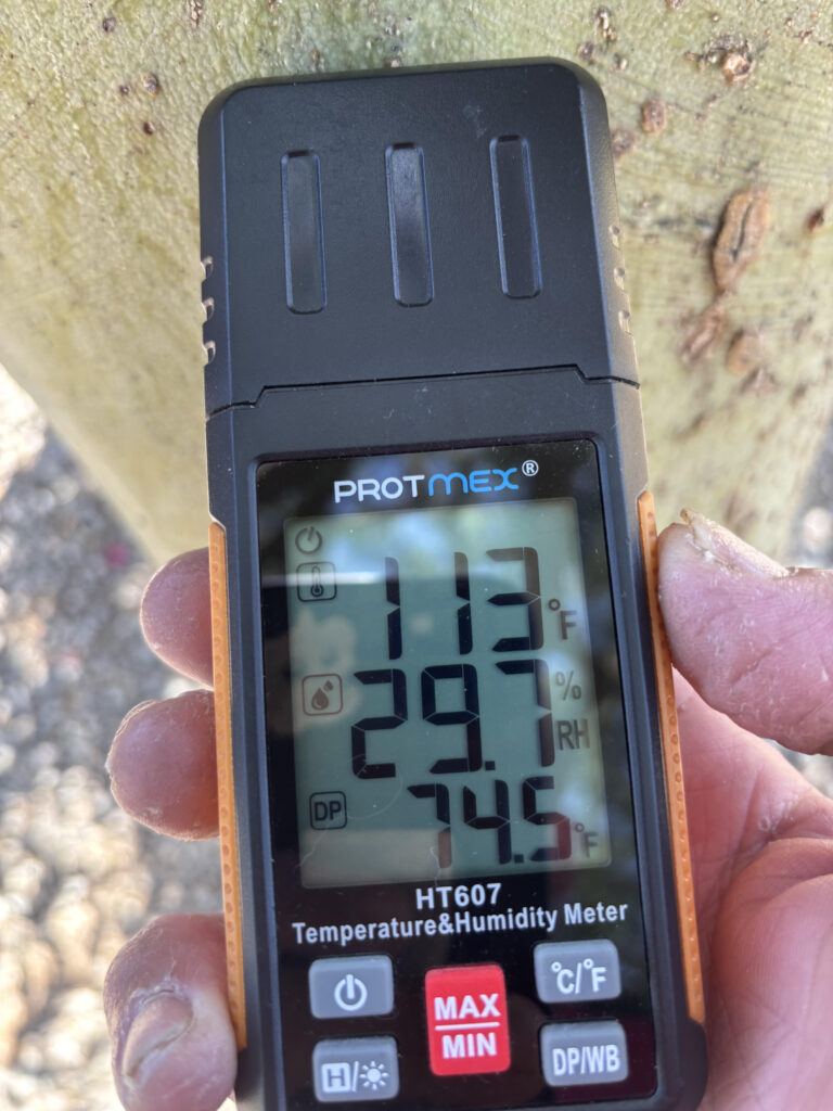 Technician checking a Tucson home wall for hidden moisture with a moisture meter